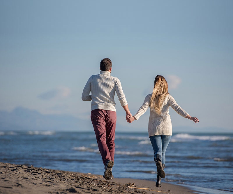 Laufendes Paar am Strand strahlt Freude und Leichtigkeit in der Beziehung aus